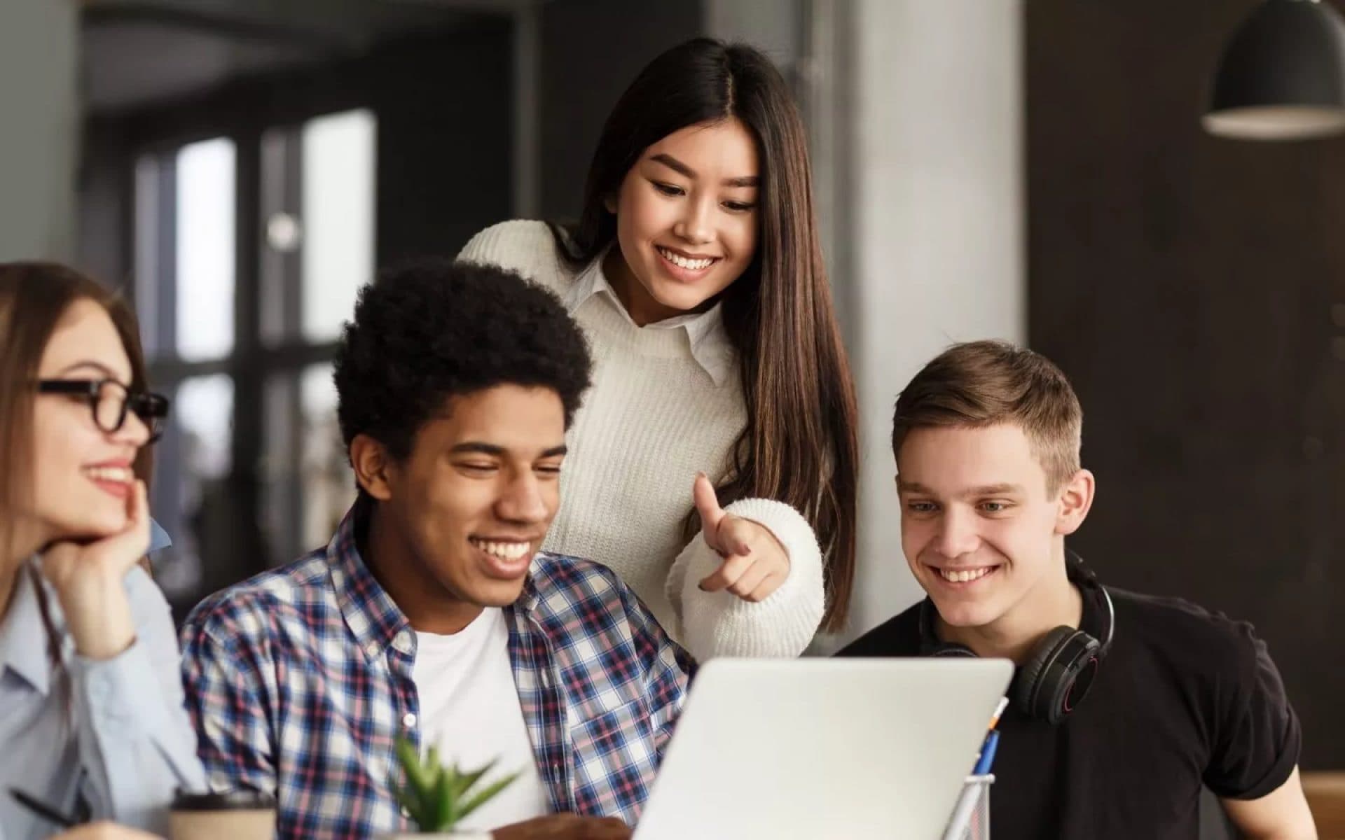 Jeunes étudiants souriants devant un ordinateur